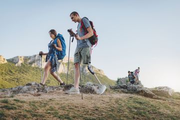 Two people walking outdoors over rocky terrain which symbolises how a mentor walks alongside a mentee to support development.